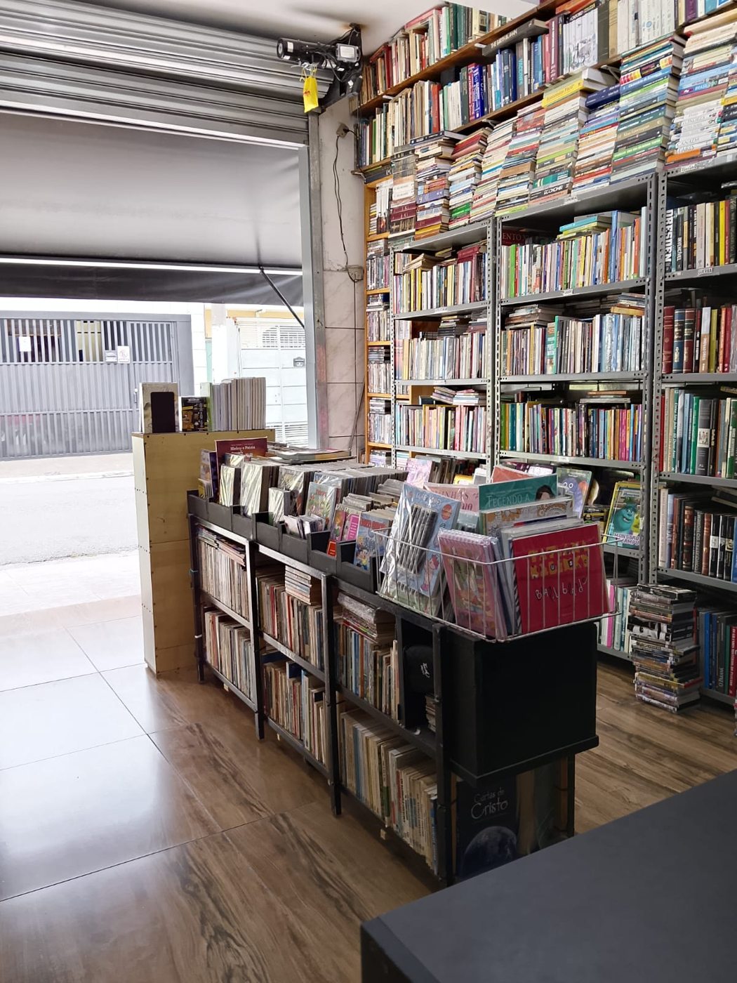 Livros e estantes próximos à entrada da Livraria Sinapse