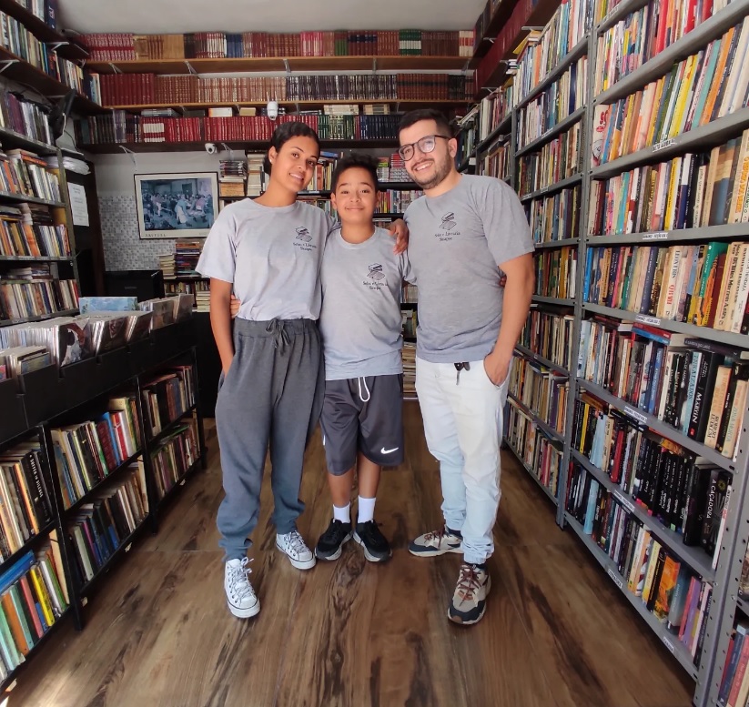 Família na Livraria Sinapse, entre as estantes de livros